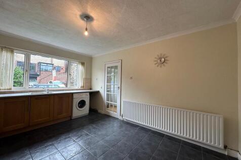 Bright kitchen with a long countertop, large wi...