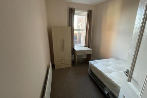 Bright, simply furnished single bedroom with a ...