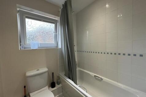 Bright, well-kept bathroom with a white tiled b...