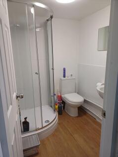 Neat bathroom with a curved glass shower enclos...