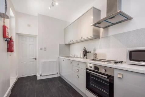 Bright, modern fitted kitchen with gloss cabine...