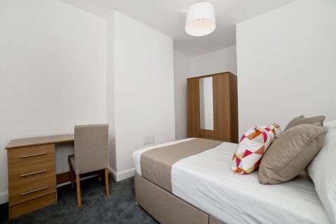 Bright, neatly furnished bedroom featuring a co...