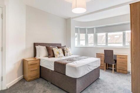 Bright, neatly styled double bedroom with a com...