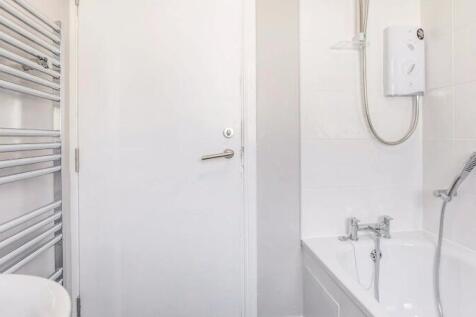 Bright, modern bathroom with clean white tiles,...