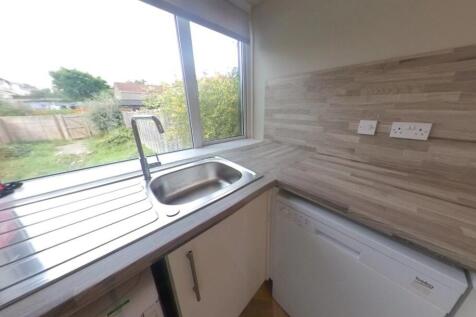 Bright galley-style kitchen with a large window...