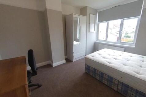 Bright, neutral bedroom featuring a comfortable...