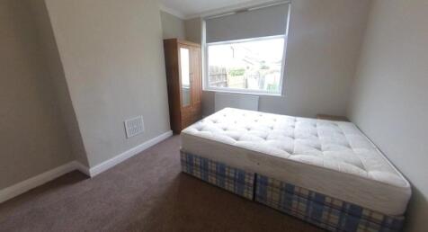 Bright, simply furnished bedroom with a double ...