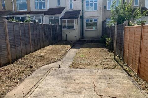 Private rear garden with a central paved path, ...