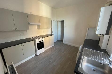 Bright galley-style kitchen with modern laminat...