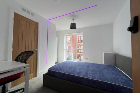 Bright, modern double bedroom with a large wind...