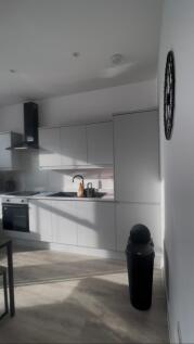 Bright modern kitchen with sleek white cabinetr...