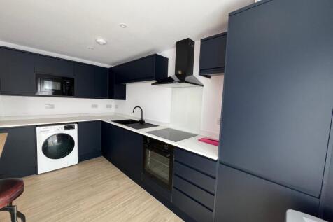 Modern fitted kitchen with dark navy cabinets, ...