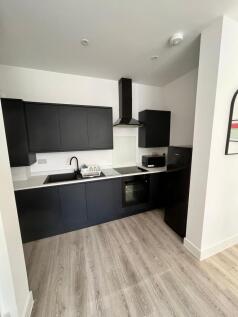 Modern fitted kitchen with sleek dark cabinets,...