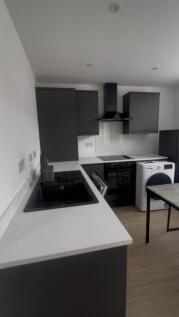 Modern kitchen with dark cabinetry, white marbl...