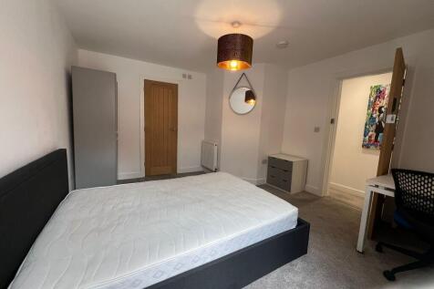 Bright, neutrally decorated double bedroom with...