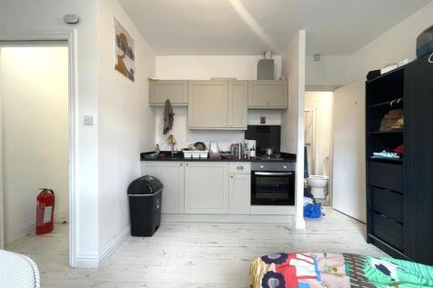 Bright studio room with a compact fitted kitche...