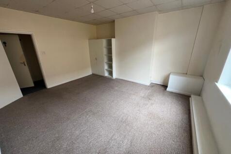 A spacious double bedroom featuring neutral wal...