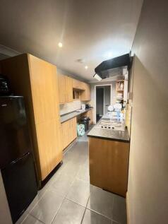 A modern kitchen featuring wooden cabinetry and...