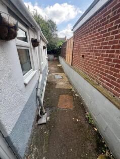 Narrow side path alongside a house with a mix o...