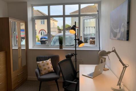 Bright, neatly furnished bedroom with a large f...