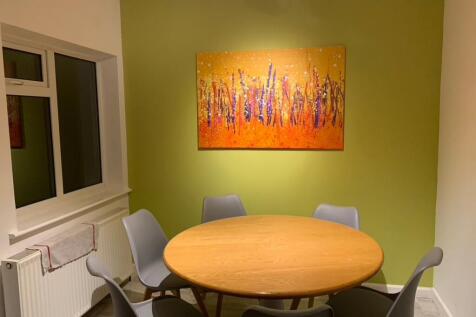 Bright, modern dining area with a round wooden ...