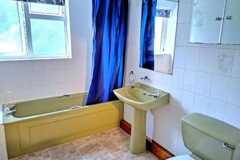 Bright tiled bathroom with a bathtub, pedestal ...