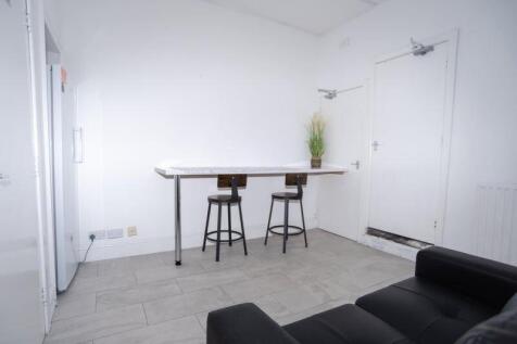 Bright, minimalist kitchen/dining area with a h...