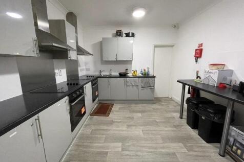 Modern fitted kitchen with sleek grey cabinets,...