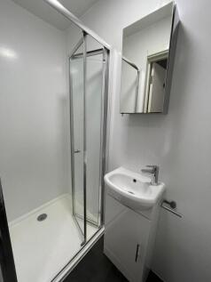 Bright, modern bathroom with a corner shower en...