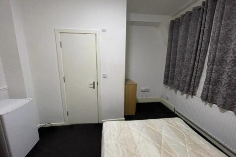 Simple, tidy bedroom with a large window dresse...