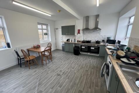 Bright communal kitchen with two large ovens, p...