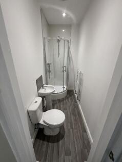 Neat, modern bathroom with a corner shower cubi...