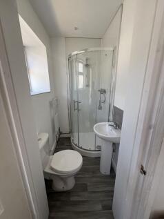 Bright, modern bathroom with a corner glass sho...