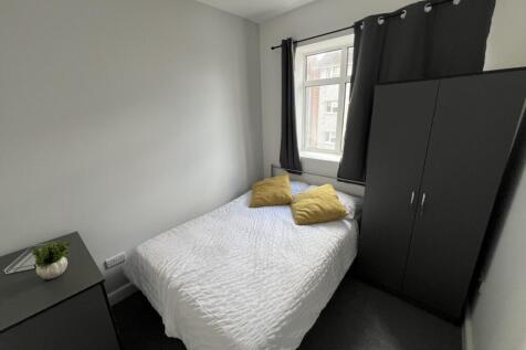 Bright, neatly presented bedroom featuring a do...