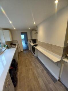 Modern galley kitchen with sleek white countert...