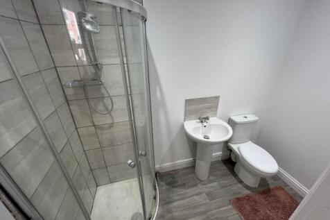 Modern bathroom featuring a curved glass shower...