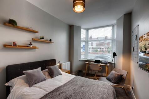 Bright, well-styled bedroom with a comfortable ...