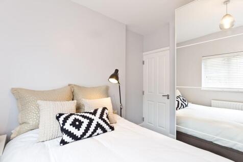 Bright, neatly styled bedroom with a comfortabl...