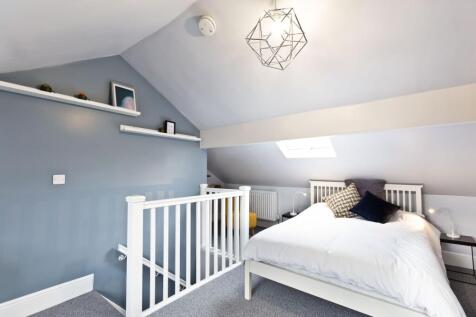 Bright, modern attic-style bedroom with a white...