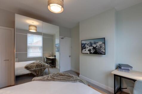 Bright, modern double bedroom with mirrored bui...