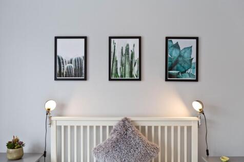 Bright, neatly styled bedroom with a white slat...