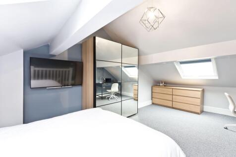 Bright, stylish loft bedroom with a large mirro...