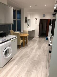 Bright, modern galley kitchen with light wood f...