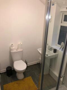 Compact, modern bathroom with a corner shower, ...