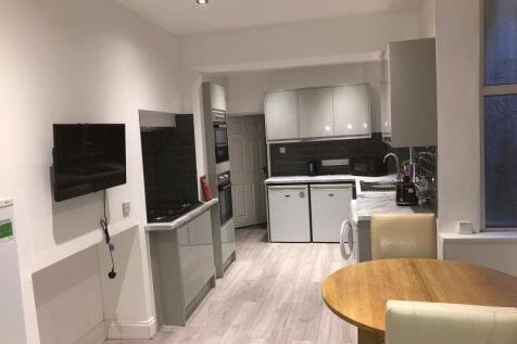 Modern open-plan kitchen with sleek grey cabine...