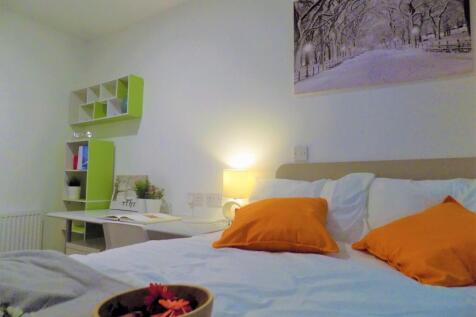 Bright, neatly styled bedroom featuring a comfy...