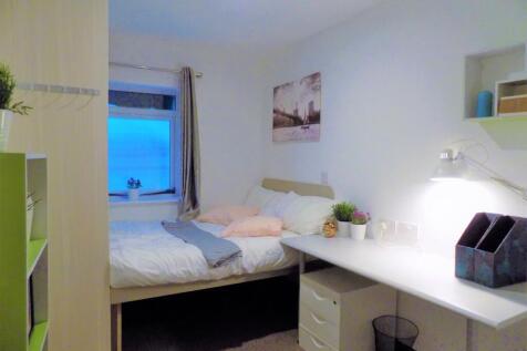 Bright, neatly styled bedroom with a comfortabl...