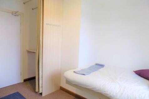 Bright, simply furnished single bedroom with a ...