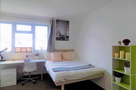 Bright, neatly furnished bedroom with a double ...
