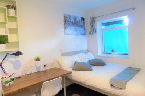 Bright, neatly furnished bedroom with a double ...